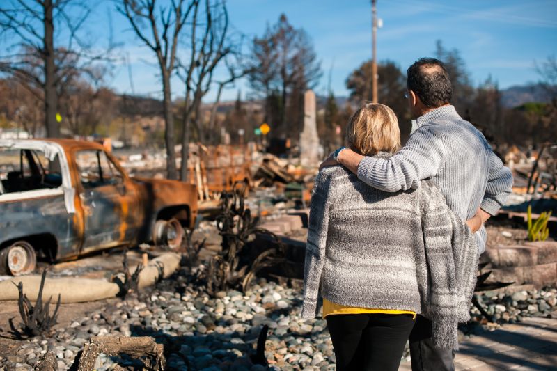 Couple looking at bush fire damage