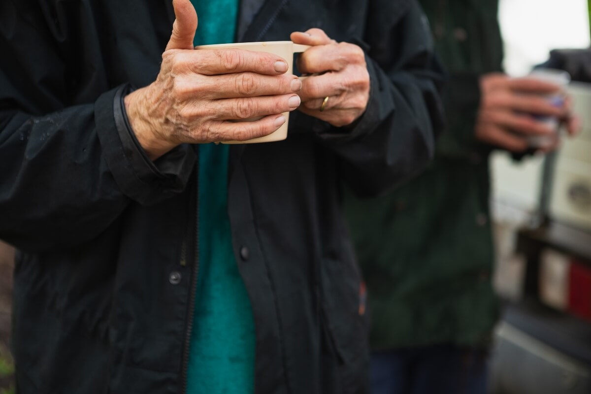 Volunteer is holding a coffee cup